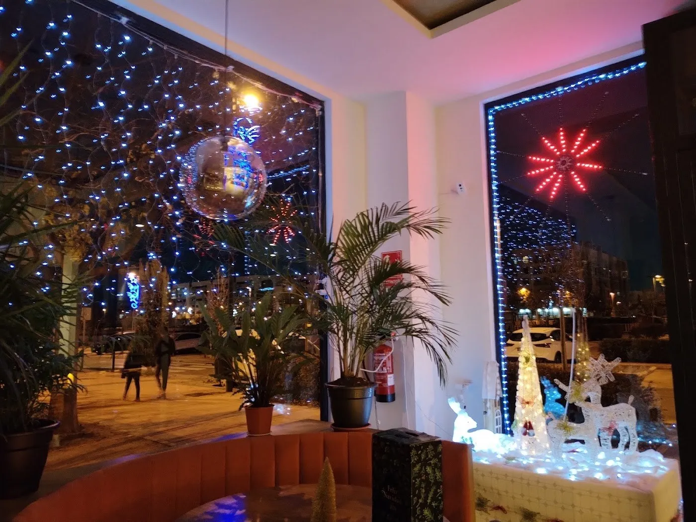 Ventanal del comedor de noche, con luces de Navidad en la calle