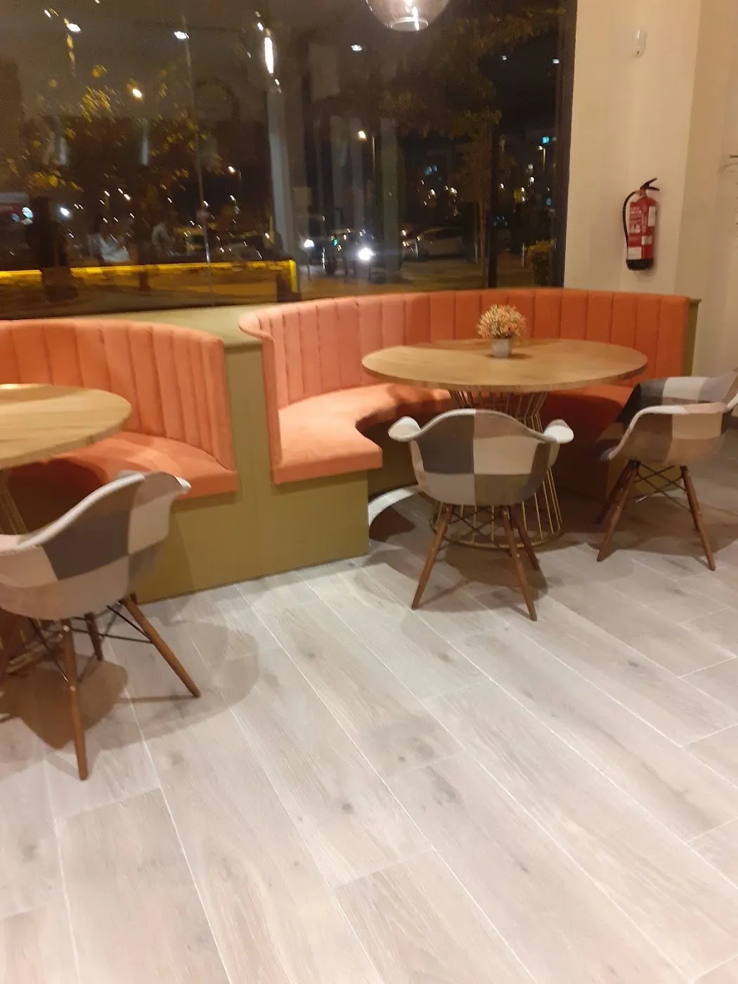 Rincón de bancos tapizados en terracota con mesa redonda